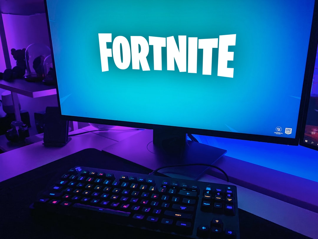 black flat screen computer monitor with black computer keyboard - Fortnite game loading on a gaming setup., tags: youtuber epic - unsplash